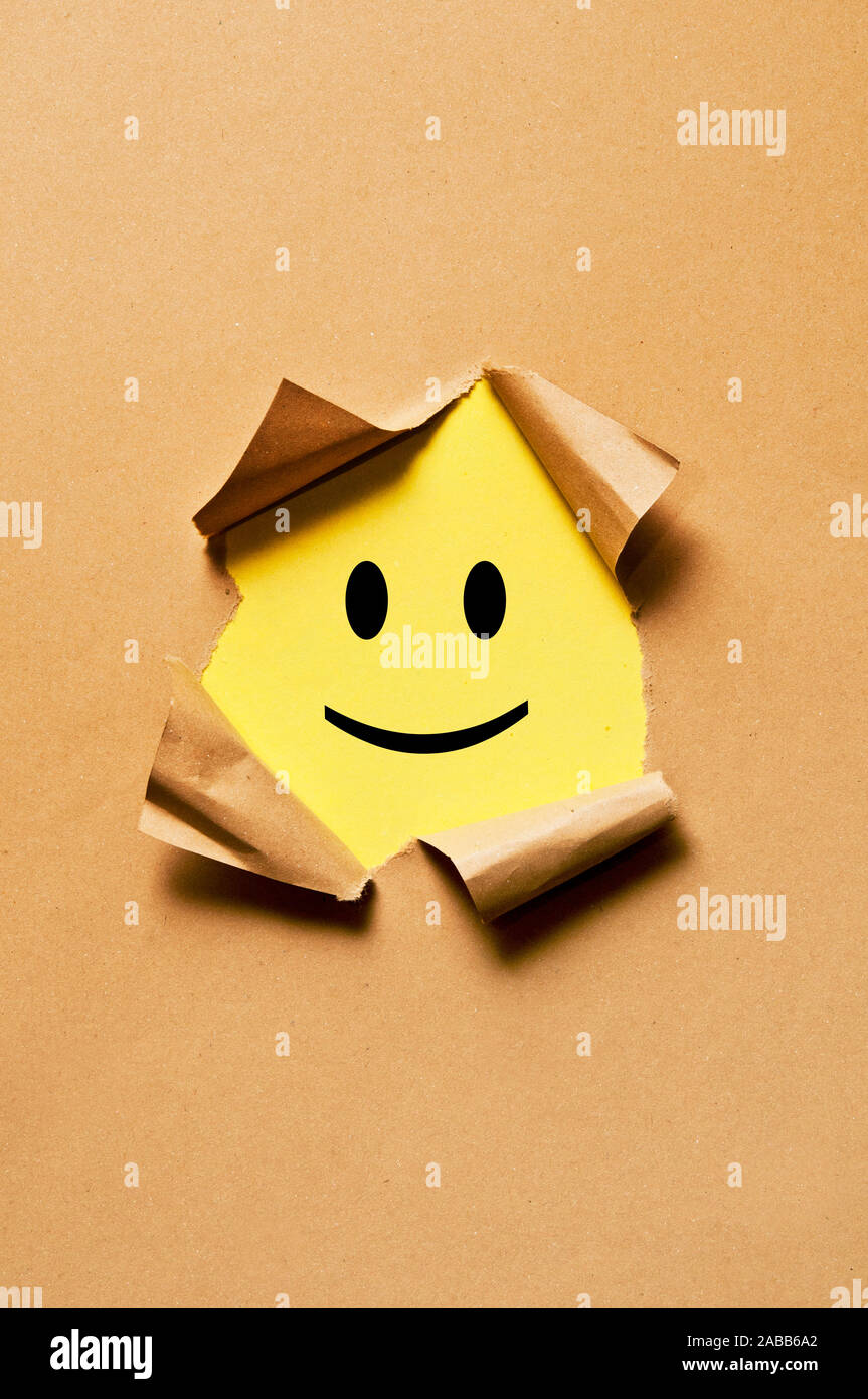 Smiley Emoticon unter gerippt, Papier Stockfoto