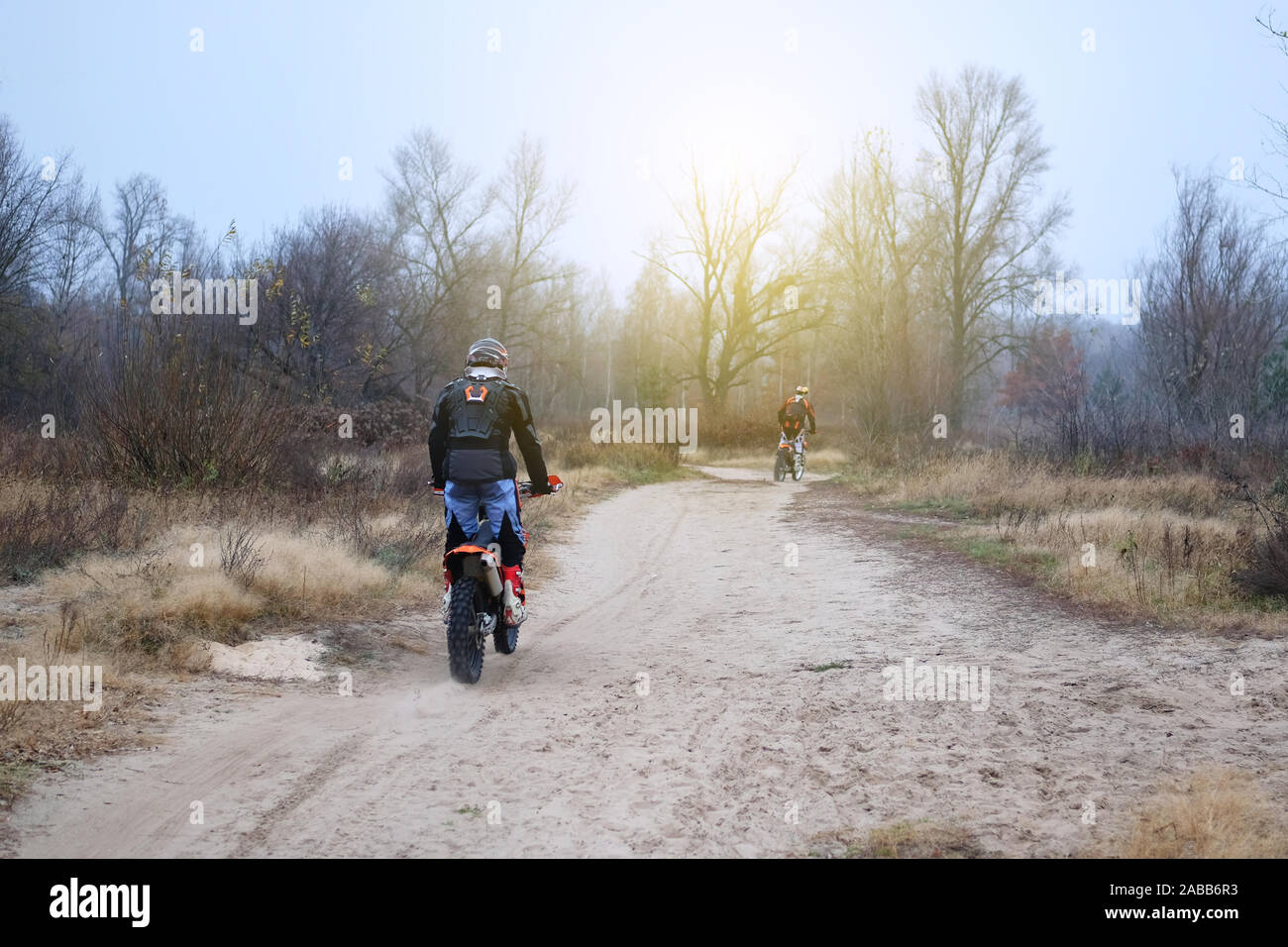 Sport und Aktiv gesund leben Konzept. Motorradfahrer im schützenden im Spätherbst Park. Reiten auf Motorrad an einem sonnigen Tag unter Bäumen. Gesunde Lebensweise. Stockfoto