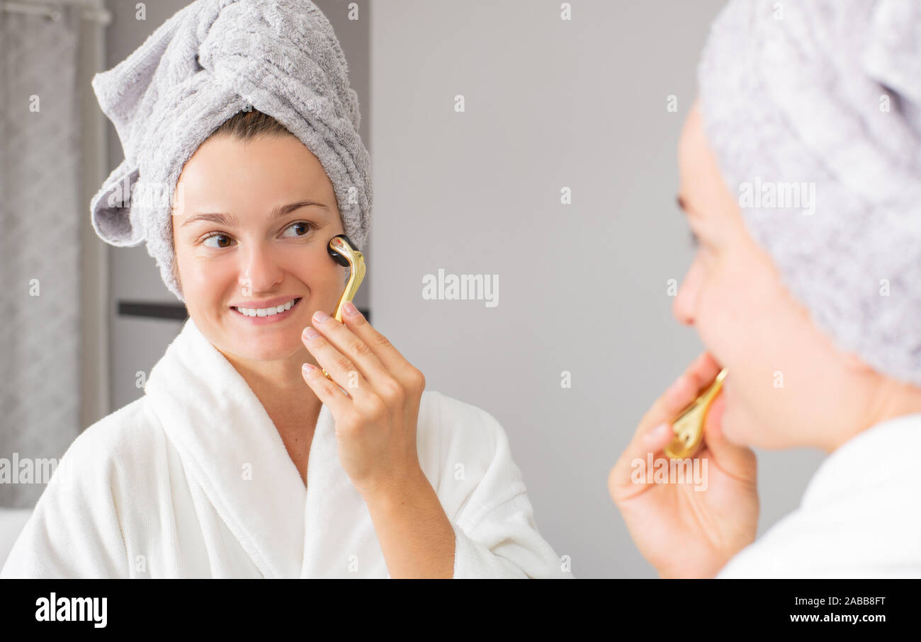 Schöne Frau ist mit Anti aging Derma Roller. Frau ist das Verfahren auf das  Gesicht mit meso Roller in Home Stockfotografie - Alamy