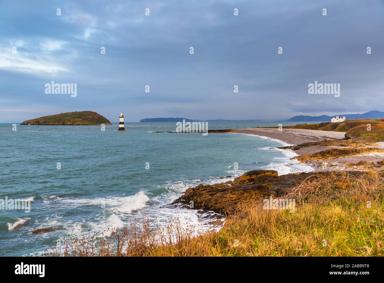 Du Trwyn penmon Leuchtturm (Leuchtturm) auf der östlichen Spitze der Insel Anglesey mit Papageitaucher (ynys Seiriol) im Abstand von einer Klippe Stockfoto