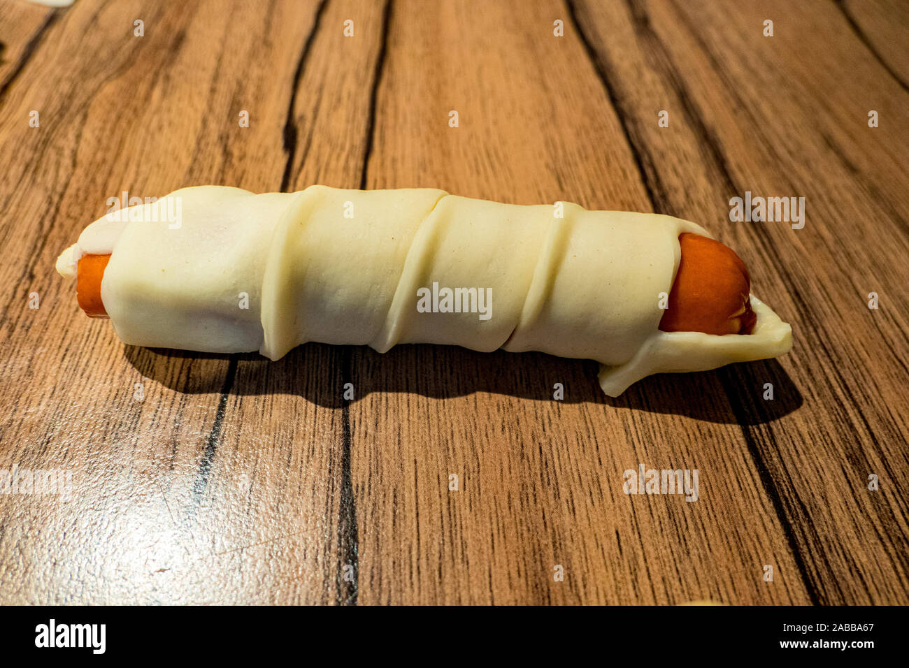 Kleine Würstchen im Teig bestreichen als Snack Stockfoto