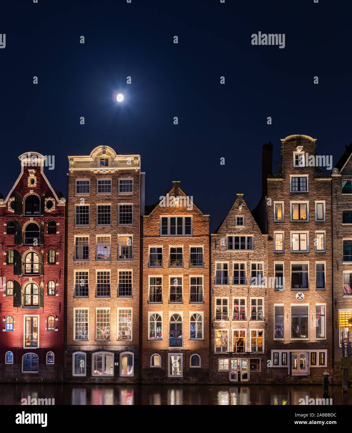 Traditionelle holländische Gebäude am Damrak bei Nacht, Amsterdam, Niederlande Stockfoto