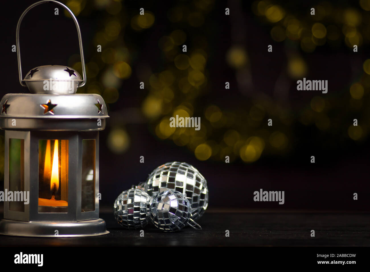 Festliche Laterne und Weihnachtsschmuck gegen glänzenden Hintergrund Stockfoto