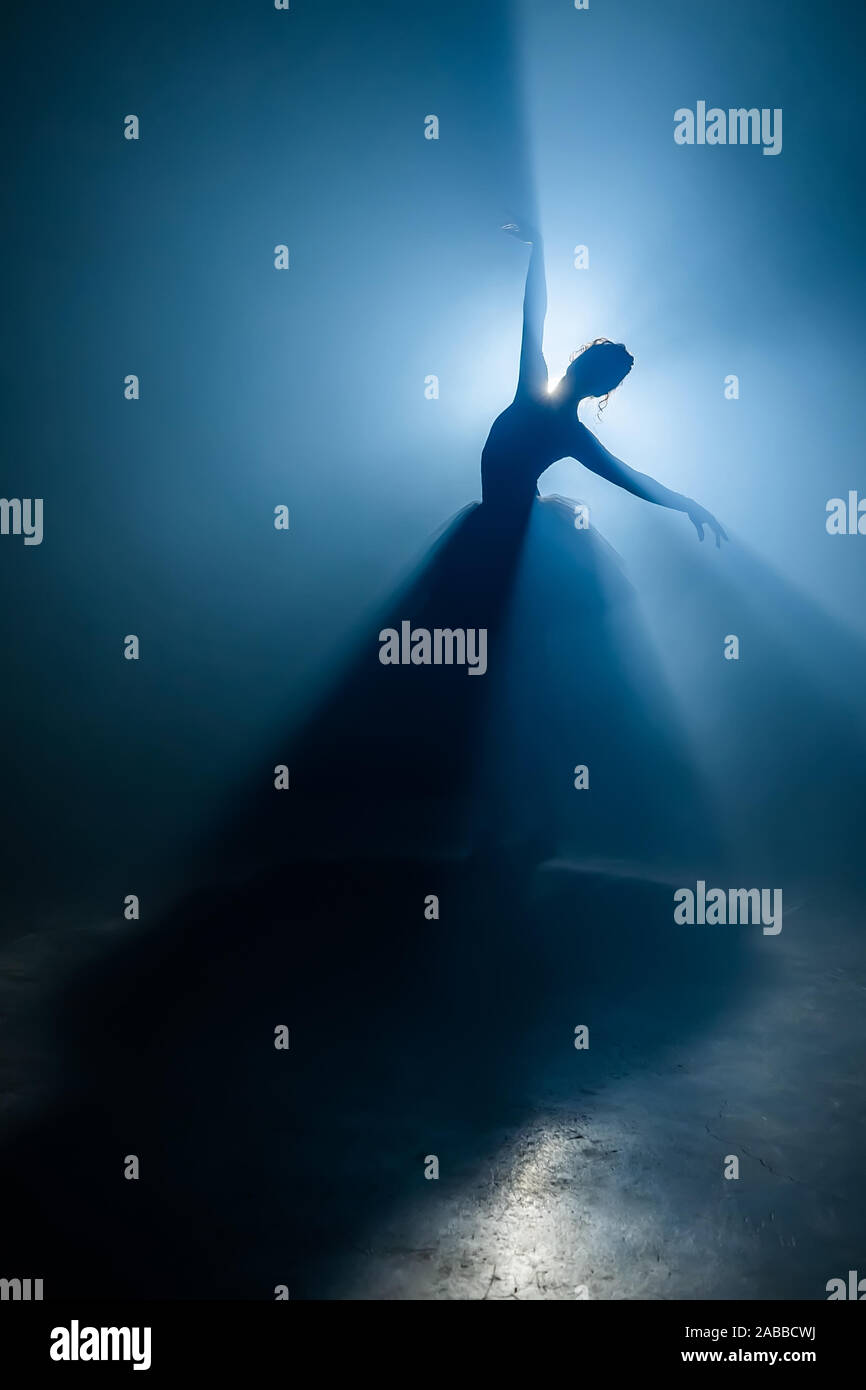 Solo Performance von Ballerina in Tutu gegen den Hintergrund der leuchtende Scheinwerfer Stockfoto