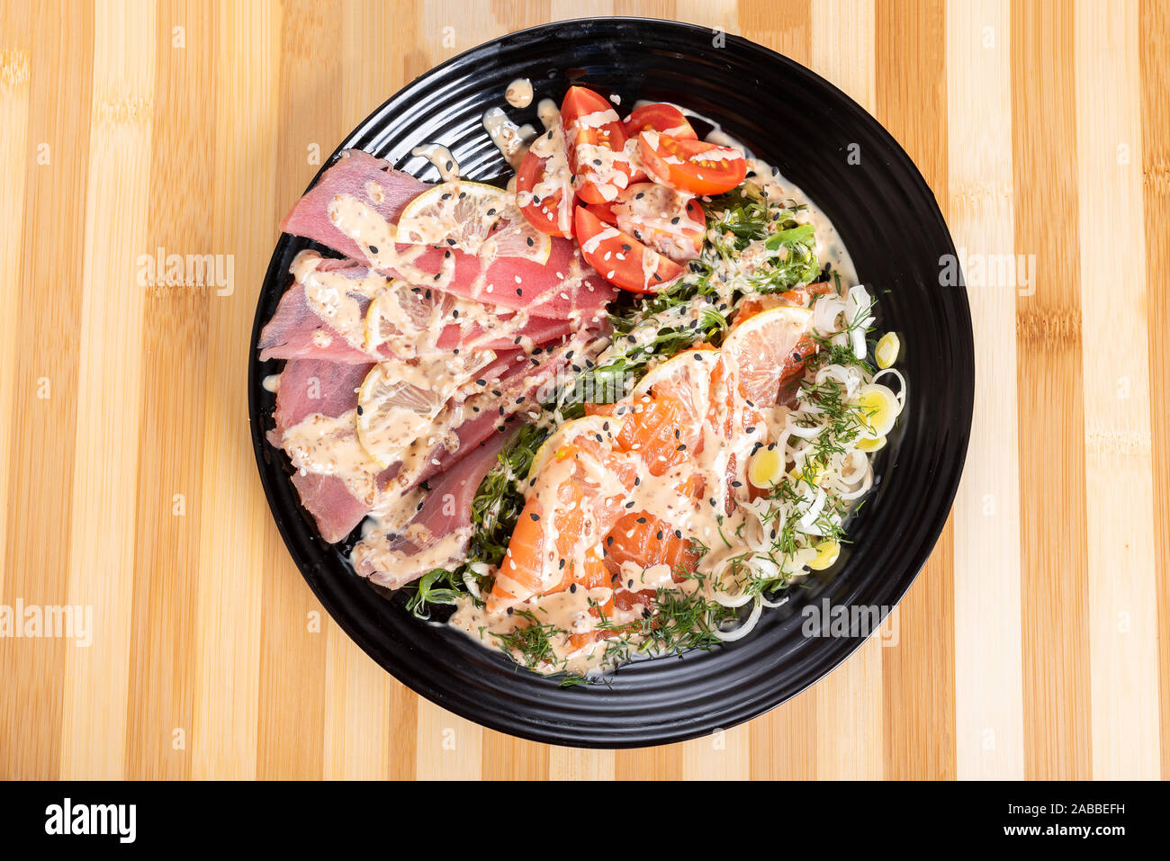 Lachs und Thunfisch Sashimi in einem Salat mit Kräutern. Stockfoto