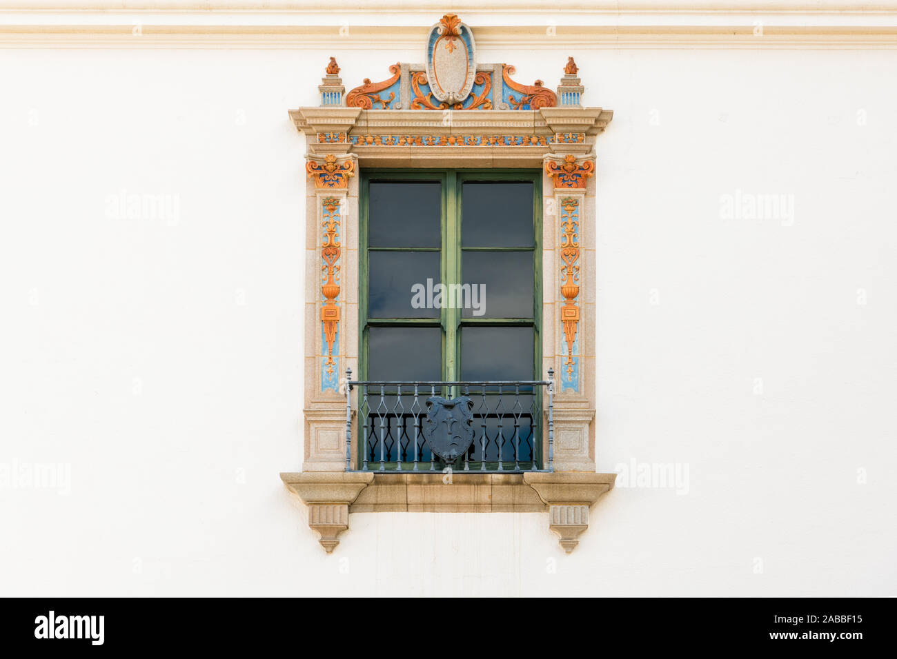 Schönen verzierten Fenster mit dekorative Verkleidung mit gelben und blauen Design Elemente in weißer Putz an der Wand eines historischen Gebäudes in Santa Barbara, Ca Stockfoto