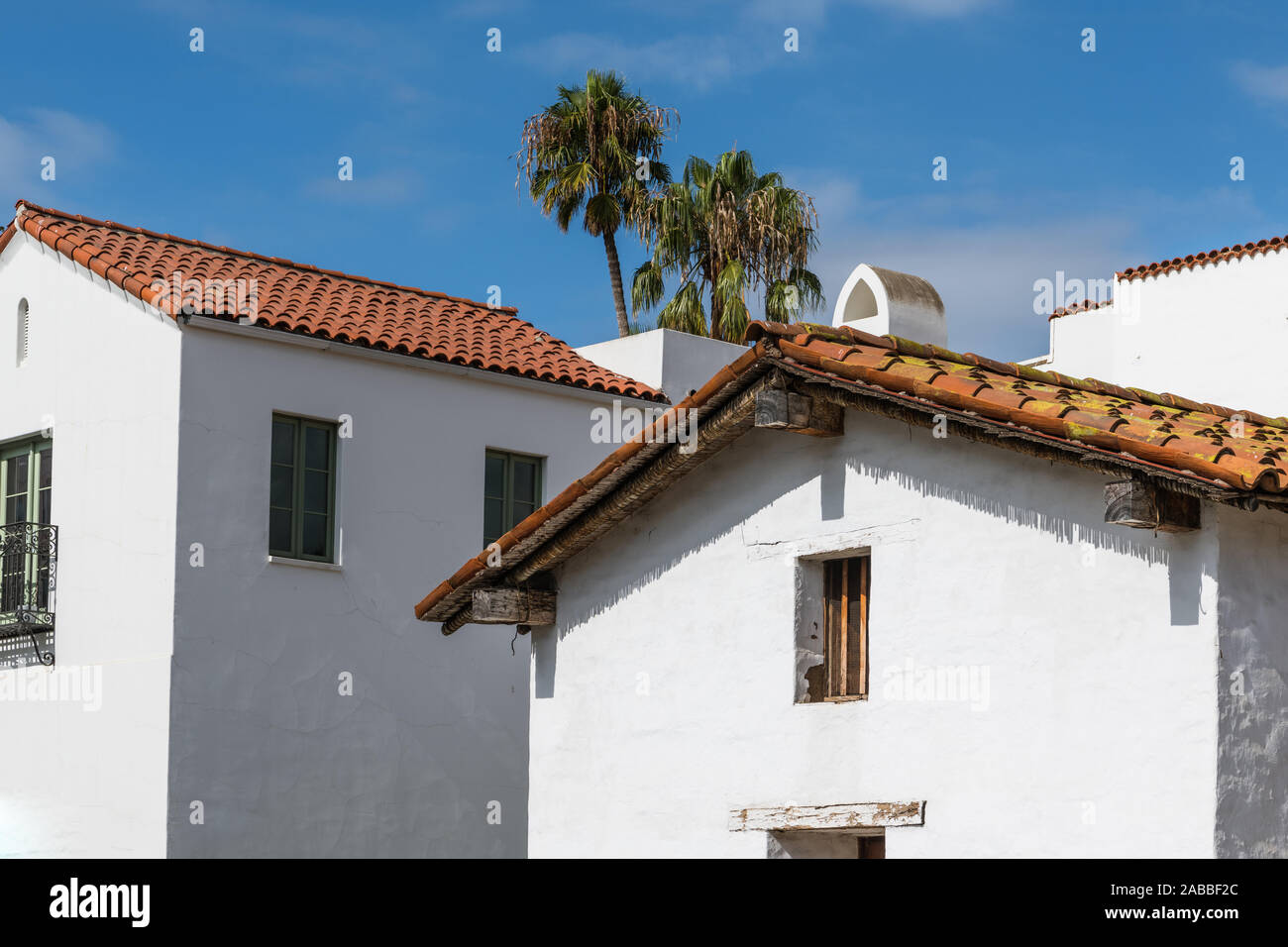 Neue und alte Gebäude im spanischen Stil mit weiß verputzten Wänden und roten Ziegeldächern unter einem blauen Himmel mit Palmen in der Innenstadt von Santa Barbara, Kalifornien Stockfoto