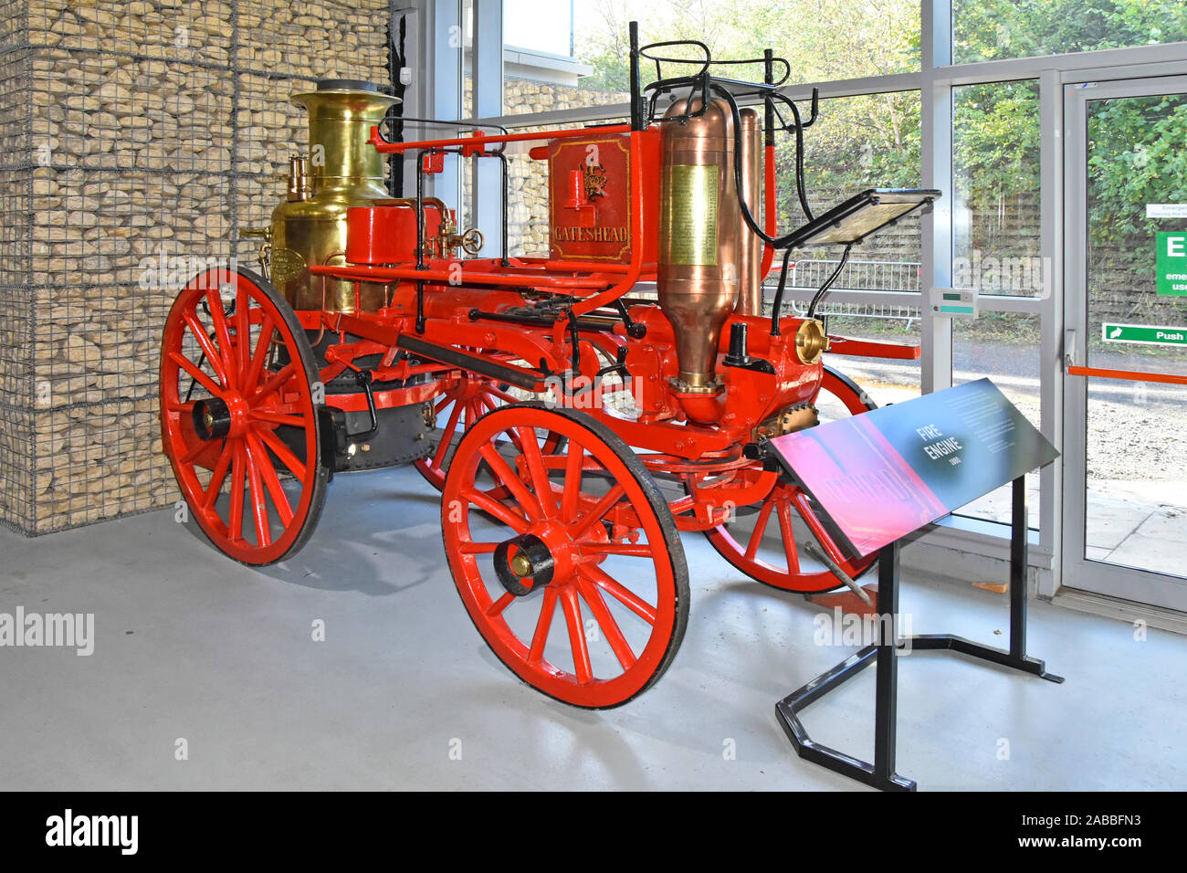 1880 historische Merryweather Pferdekutschen Löschfahrzeuge auf dem Display Vor der modernen Gabione Wand an der Fortbewegung Railway Museum Shildon County Durham GROSSBRITANNIEN Stockfoto