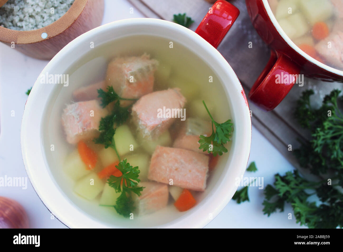 Lachs Suppentassen mit Kartoffeln und Karotten auf weißem Hintergrund, in der Nähe Stockfoto
