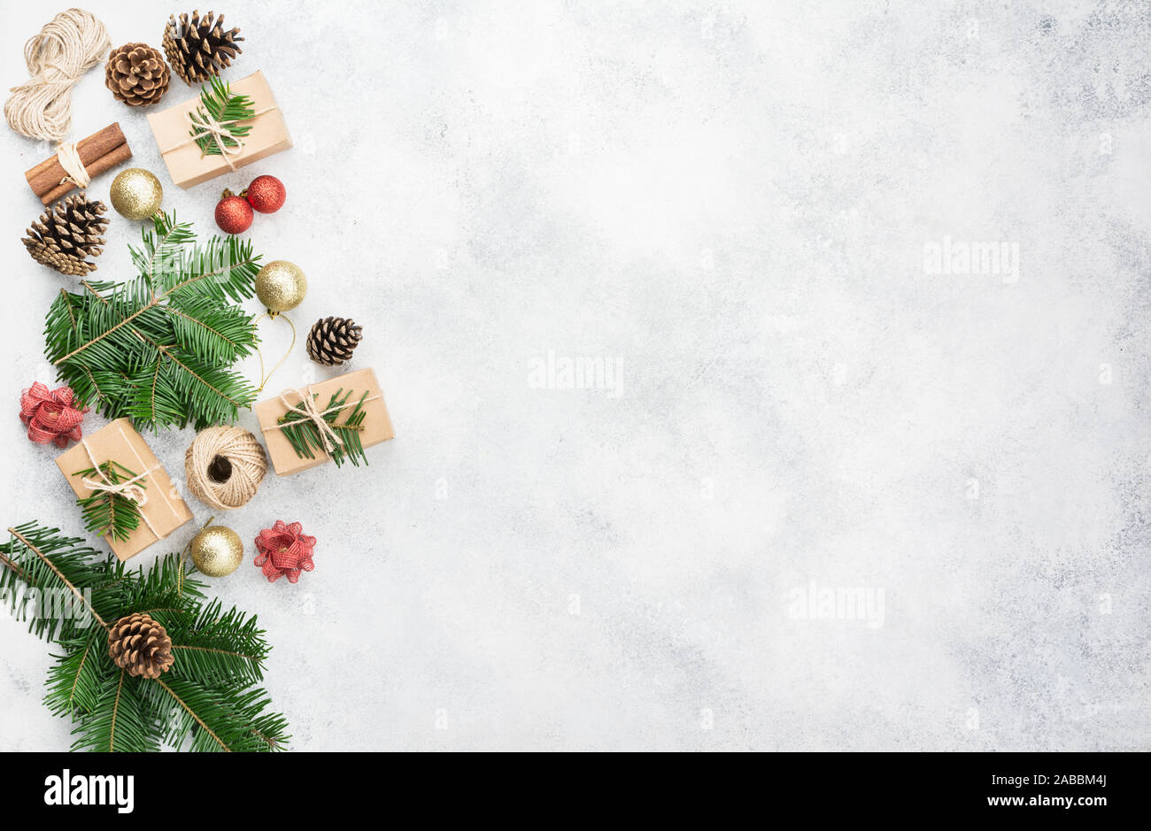 Weihnachten Hintergrund. Draufsicht der Fir Tree Branches, braun Geschenkboxen, verschiedenen Verpackungszubehör, kiefernzapfen, Tags ein aus weißem Beton Tabelle, kopieren Platz für Text, selektiver Fokus Stockfoto