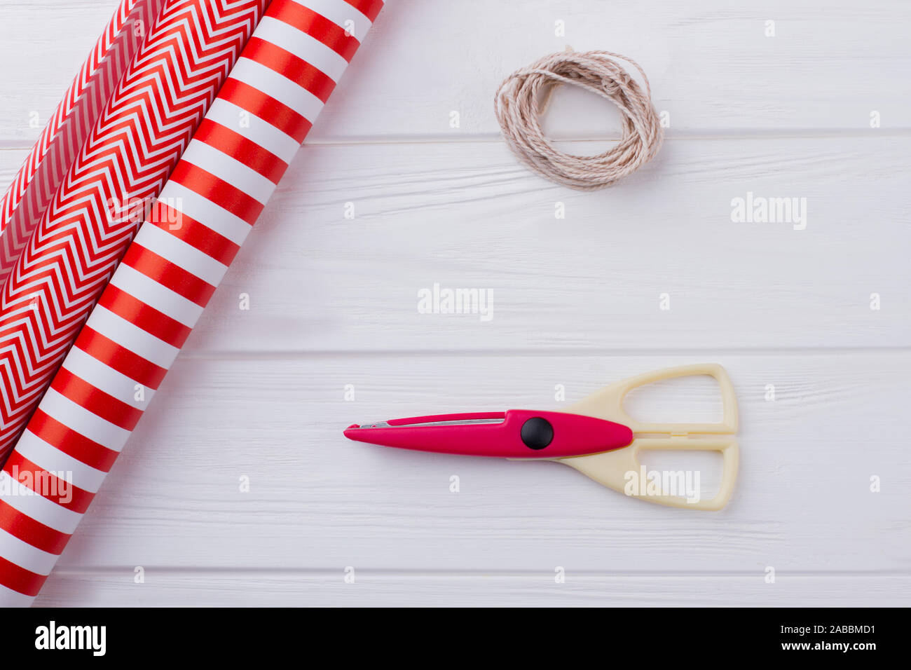 Rotes Papier, Band und Schere auf Holzhintergrund. Stockfoto