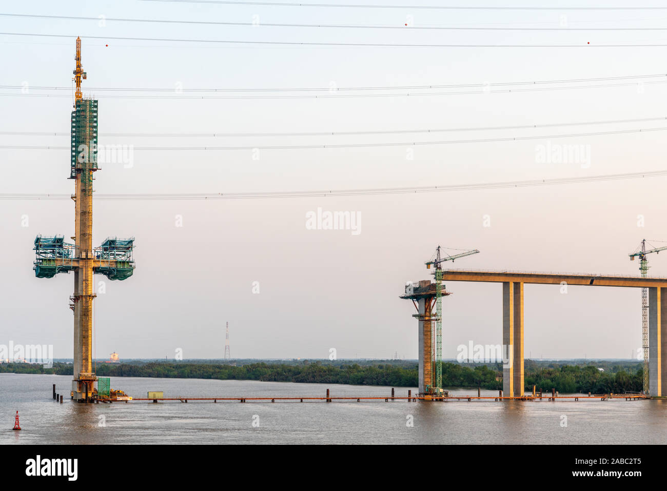 Phuoc Khanh, Vietnam - 13. März 2019: Langen Tau River bei Sonnenuntergang. Westliche Pylon und Auffahrt von Phuoc Khanh Suspension Bridge im Bau. Grau w Stockfoto