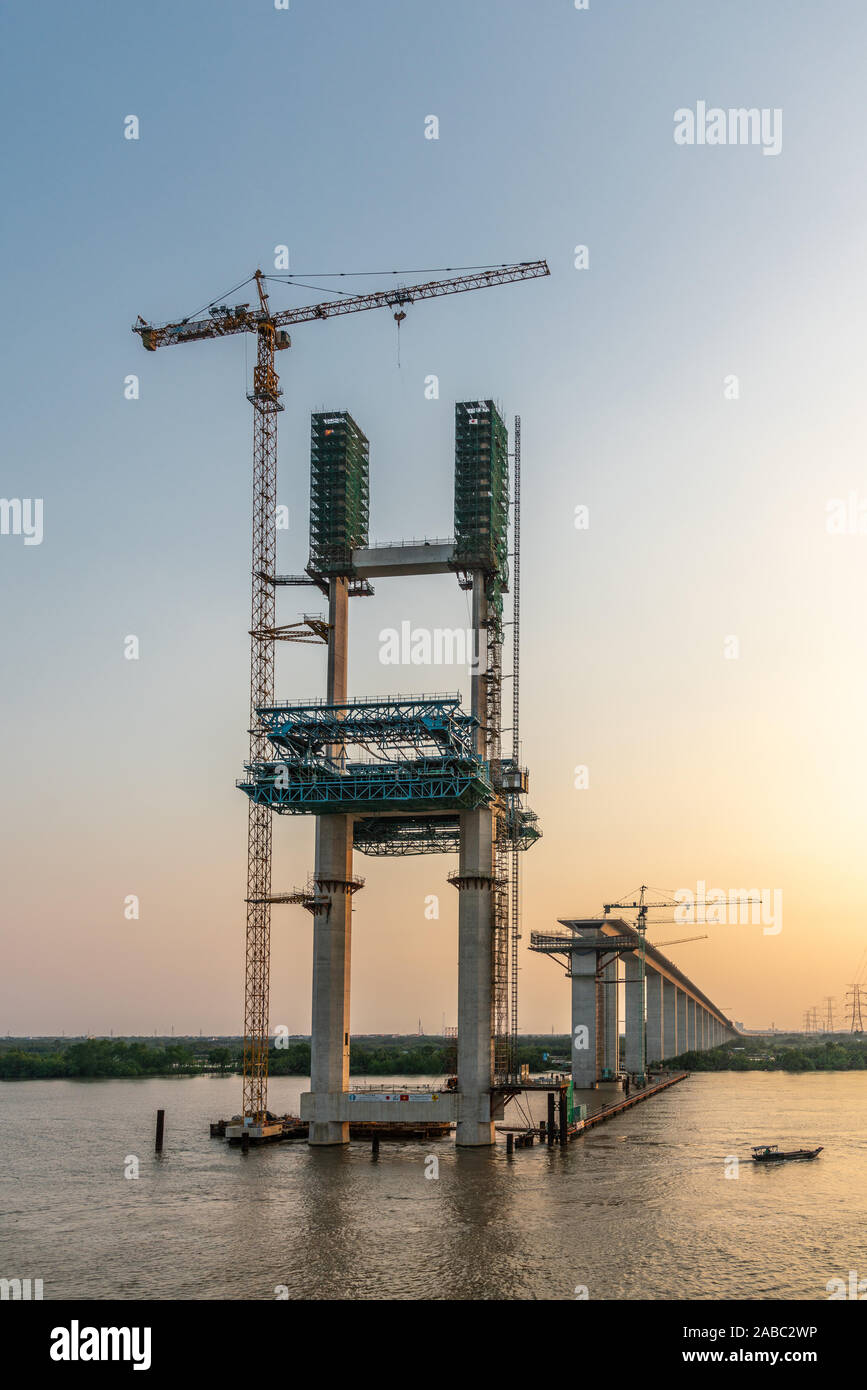 Phuoc Khanh, Vietnam - 13. März 2019: Langen Tau River bei Sonnenuntergang. Westliche Pylon und Auffahrt von Phuoc Khanh Suspension Bridge im Bau. Grau w Stockfoto