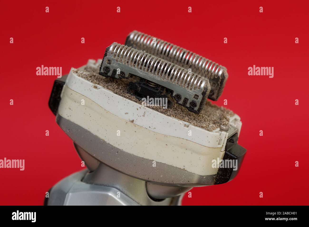 Nahaufnahme der schmutzigen Rasiermesser von Folie Elektrorasierer auf rotem Hintergrund Stockfoto