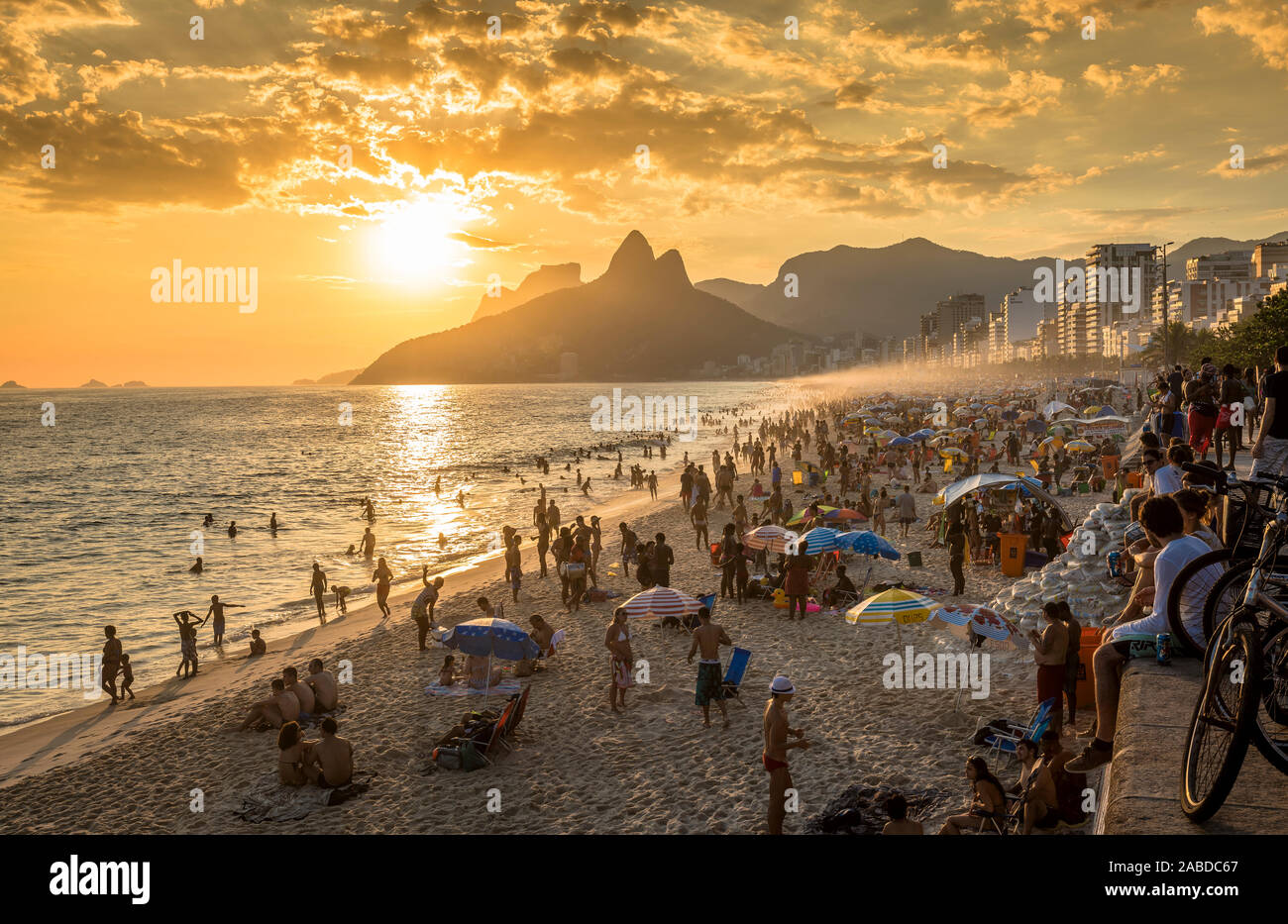 RIO DE JANEIRO, BRASILIEN - Februar 2016: Leute beobachten Sonnenuntergang am berühmten Strand von Ipanema in Rio de Janeiro. Rio de Janeiro ist Gastgeber der Olympischen Spiele 2016. Stockfoto