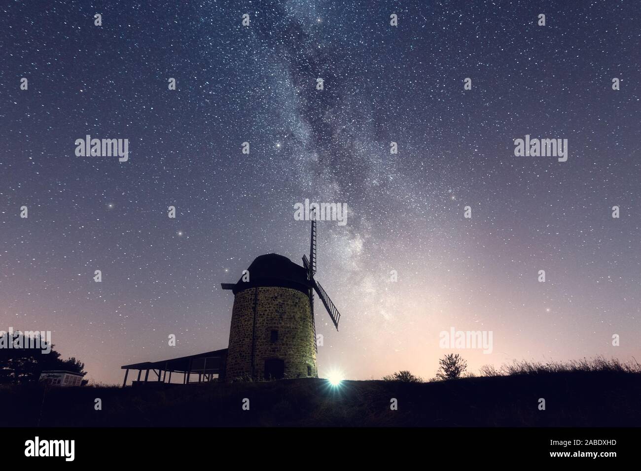 Die Milchstraße in der Nacht mit einer alten Windmühle Der Vordergrund Stockfoto