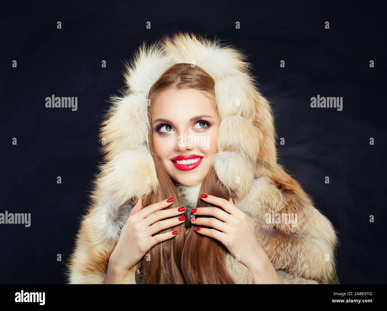 Schöne junge Winter Frau im Pelz Haube. Mädchen mit roten Nägeln suchen Stockfoto
