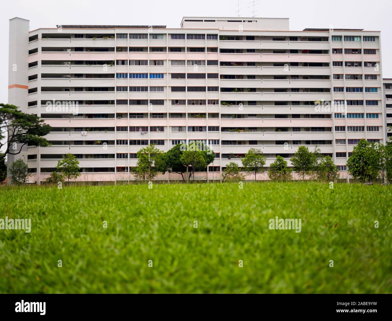 Singapur - 3. Mai 2019 - Eine alte Block der Regierung errichteten Sozialwohnungen Wohnungen (HDB Wohnungen) vor einem Gras bedeckte Feld in Singapur Stockfoto