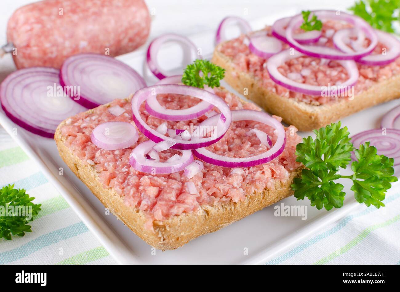 Deutsche Sandwich mit mett Boden Schweinefleisch, Bun- und rohes Fleisch mit Zwiebeln und Petersilie, Nahaufnahme Stockfoto