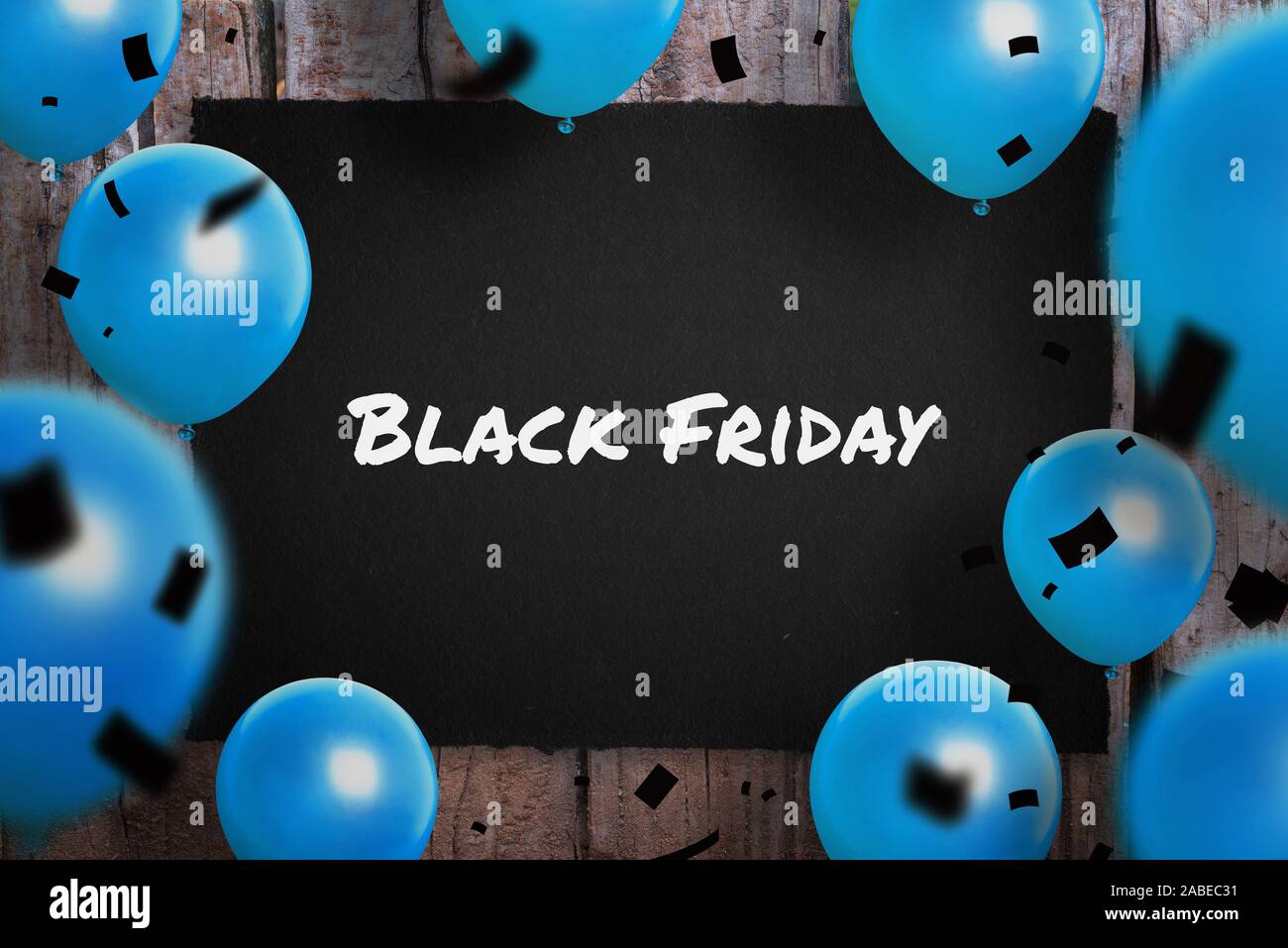 Schwarzer Freitag Text auf schwarzem Papier umgeben mit blauen Ballons und Schwarz confetty. Stockfoto