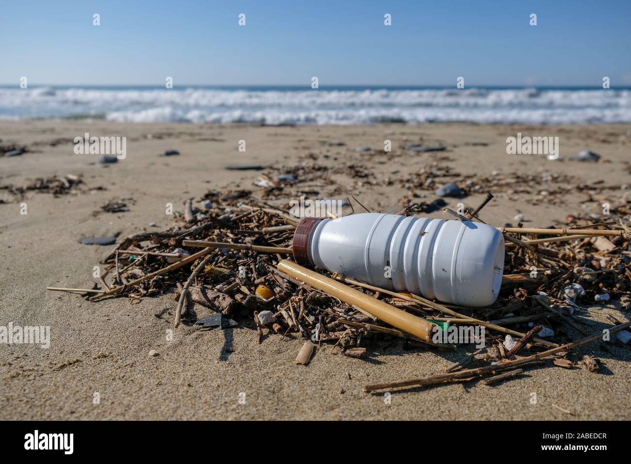 Kunststoff Milchbehälter auf Meer Küste über blur Hintergrund, Planeten retten Konzept Stockfoto