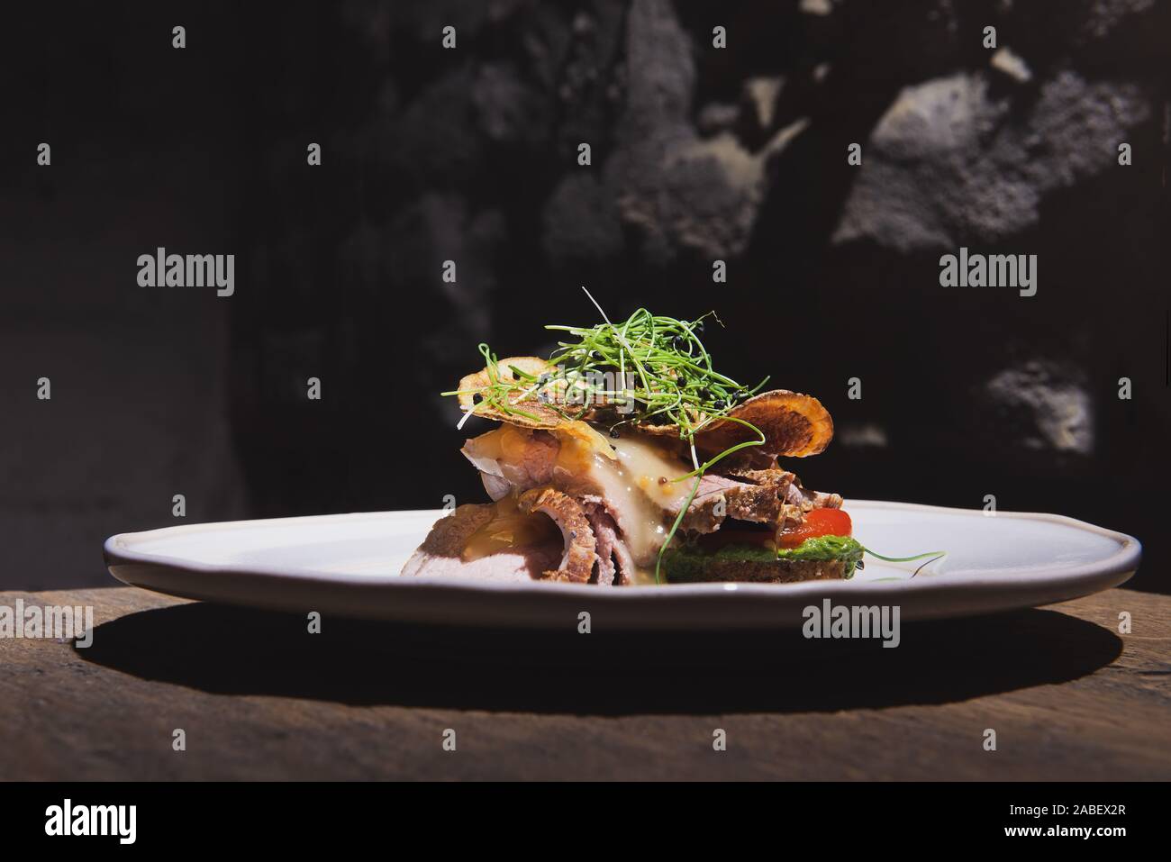 Schön appetitlich Gericht mit gebratenem Fleisch und Chips auf dem weißen Teller im Loft Stil Restaurant. Fusion-küche. Stockfoto