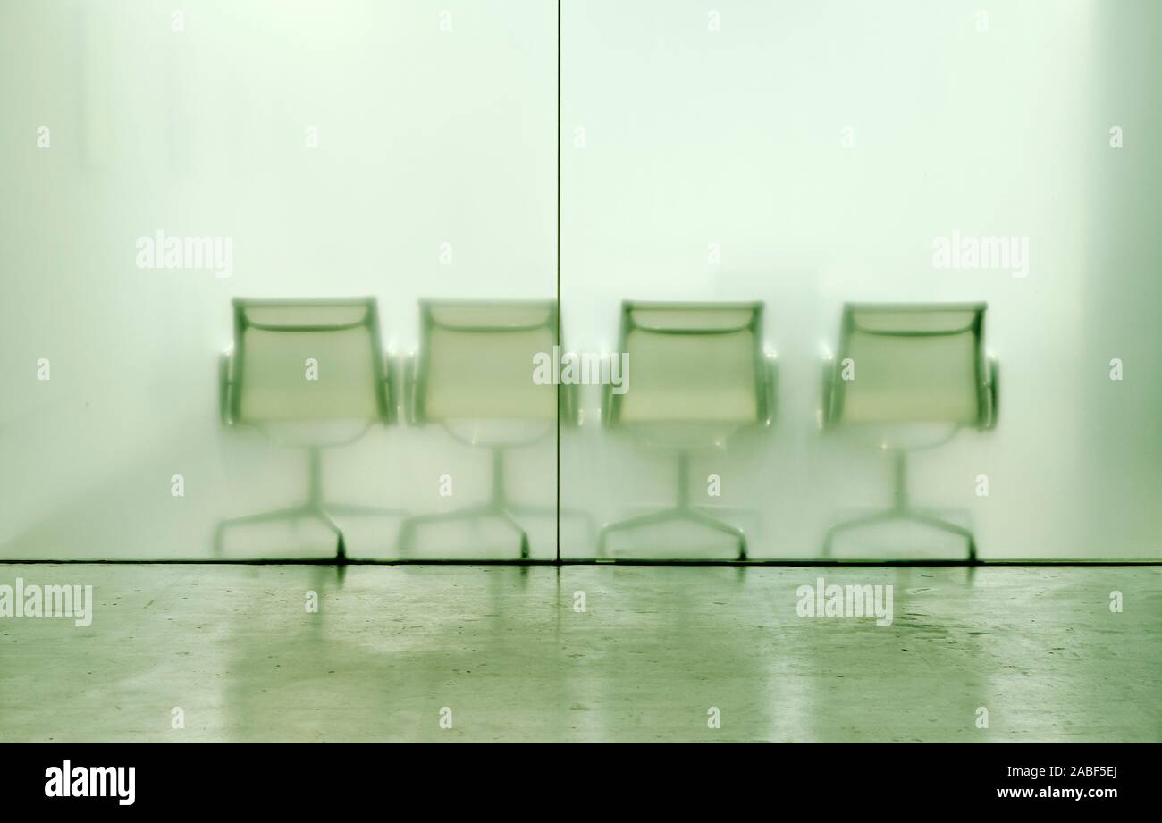 Leere Stühle hinter ein Glas Bürowand Partition - Wartezimmer - leere Büroräume - minimale Glas Büro mit Sitzecke - leere Sitze Hintergrund Stockfoto