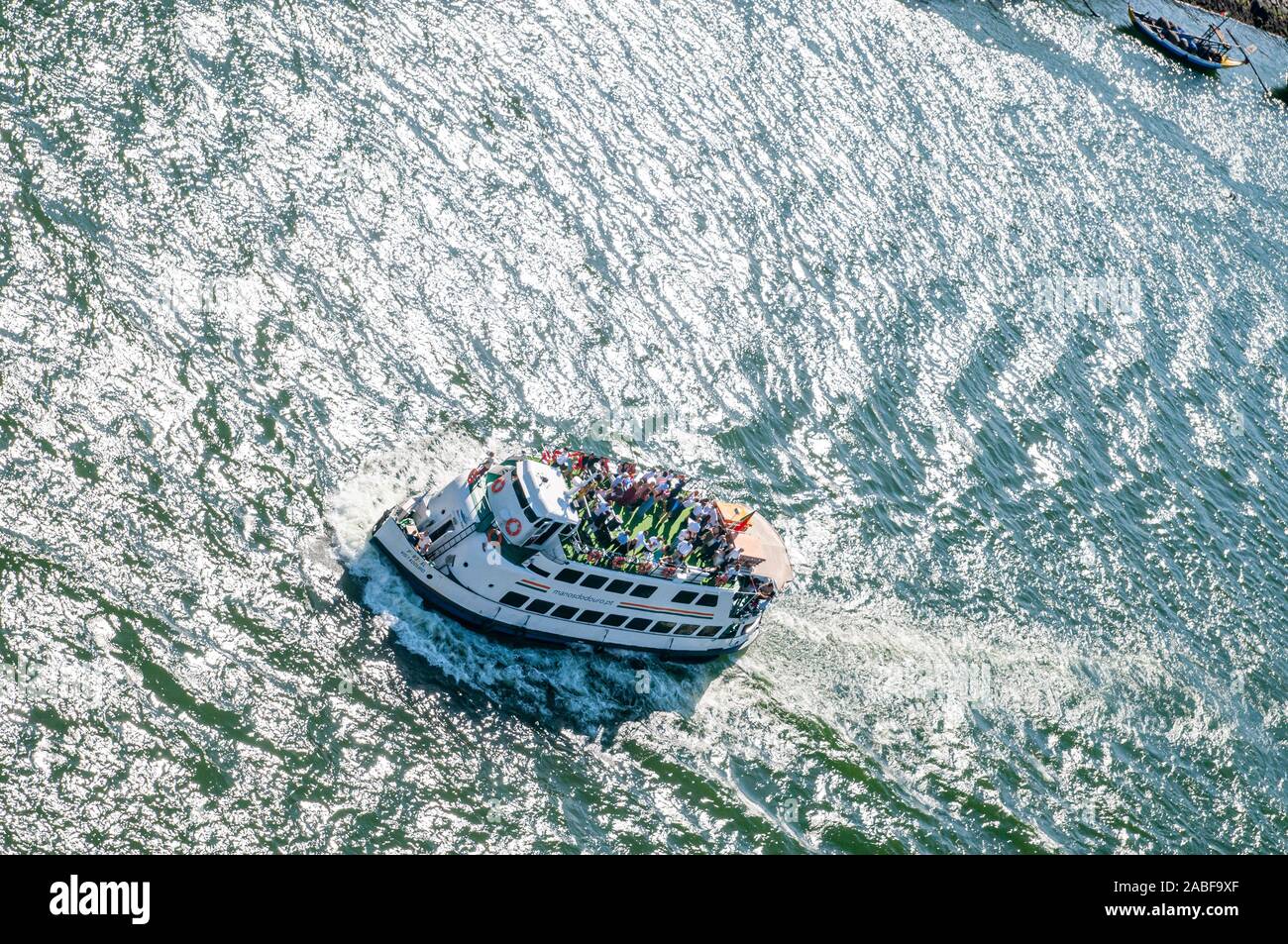 Erhöhten Blick auf eine Gruppe von Touristen feiern auf einer Bootstour auf dem Fluss Douro, Porto, Portugal das ruhige Wasser funkelt im Hintergrund Stockfoto