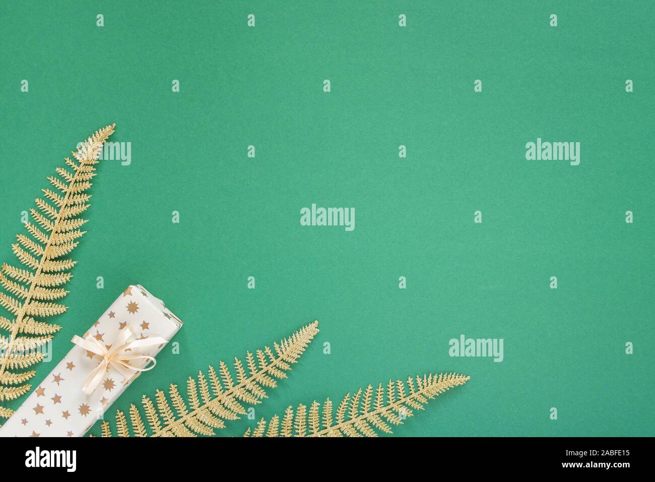 Festliche grüner Hintergrund mit gold Dekoration, Hintergrund mit Glitzer glänzenden goldenen Farnblätter und Geschenkboxen, Flach, Ansicht von oben, kopieren Raum Stockfoto