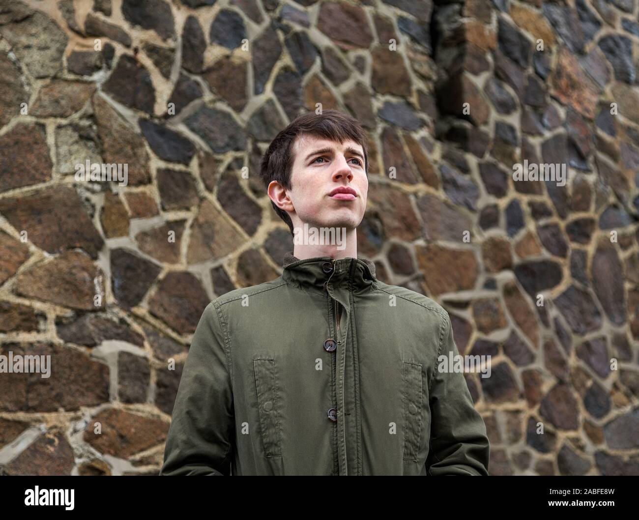 Ein hübscher junger Mann in seinem späten Teens oder frühen 20er Jahren der Blick in die Ferne mit einem starken optimistisch Ausdruck. Stockfoto