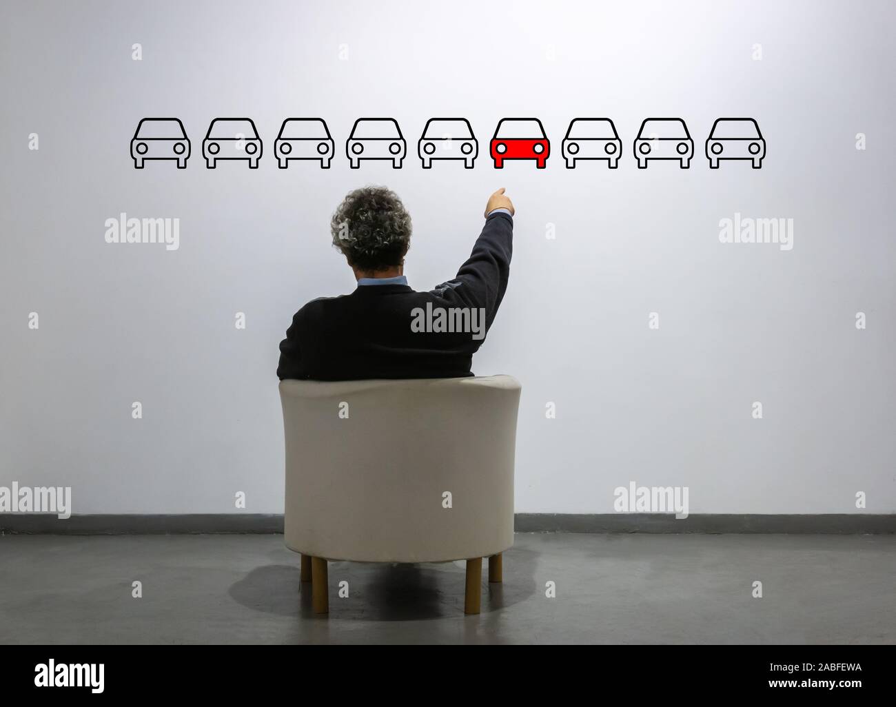 Ein Mann vor einer Reihe von Autos zeigt auf ein rotes. Konzept der Kauf, Kauf und Verkauf, Marketing Stockfoto