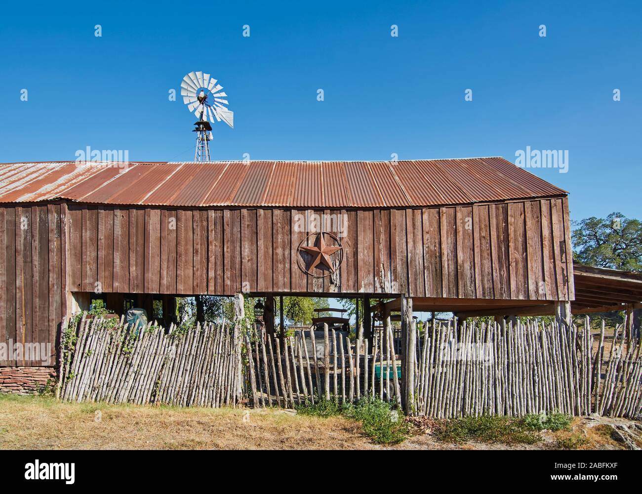 Eine alte hölzerne lean Scheune mit einer rostigen Blechdach, und die Sterne von Texas hing an der Wand auf einer Straße in Round Top, Texas. Stockfoto