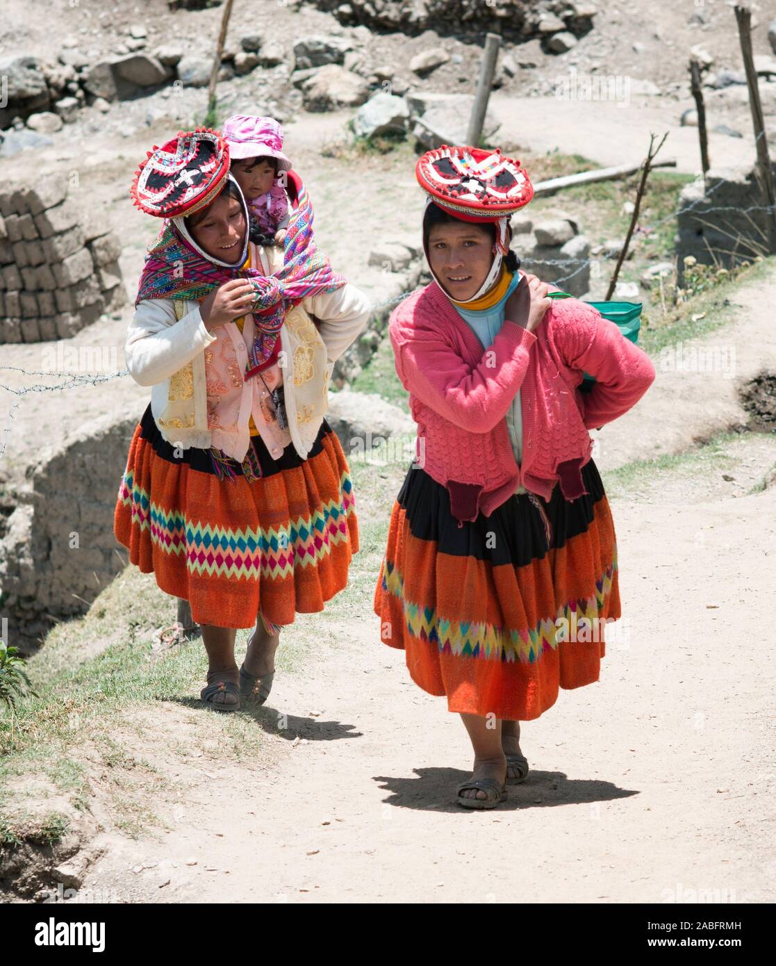 Patachancha, Cuzco, Peru - Oktober 21, 2012: Lächelnde indigene Frauen Bergauf. Einer von Ihnen, die Ihr Baby im Tragetuch Stockfoto