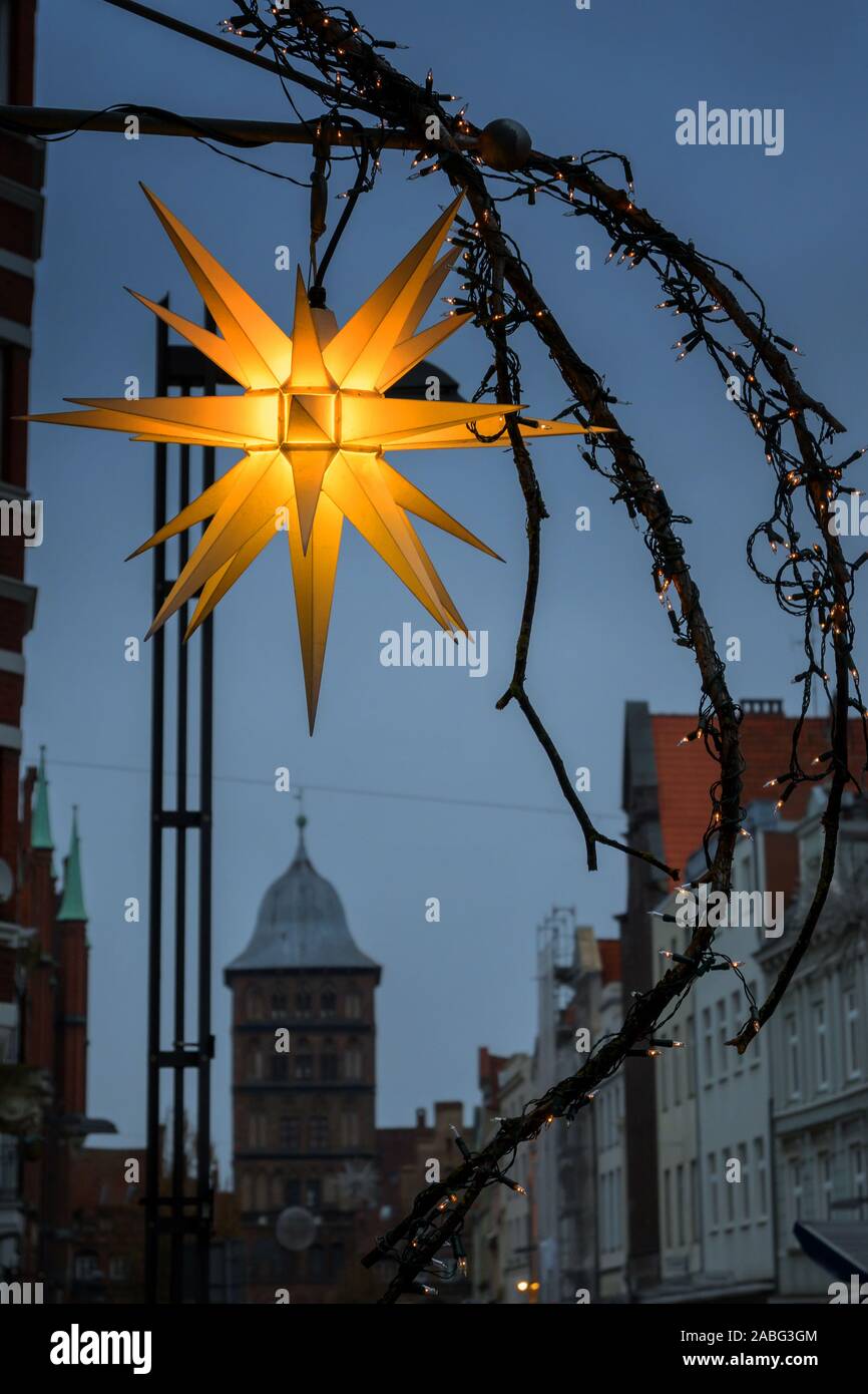 Glhende Herrnhuter Weihnachtsstern und street Dekoration vor dem Burgtor,  ein Stadttor in der Altstadt von Lbeck in der Dmmerung, ausgewhlte  konzentrieren, verschwommen Stockfotografie - Alamy