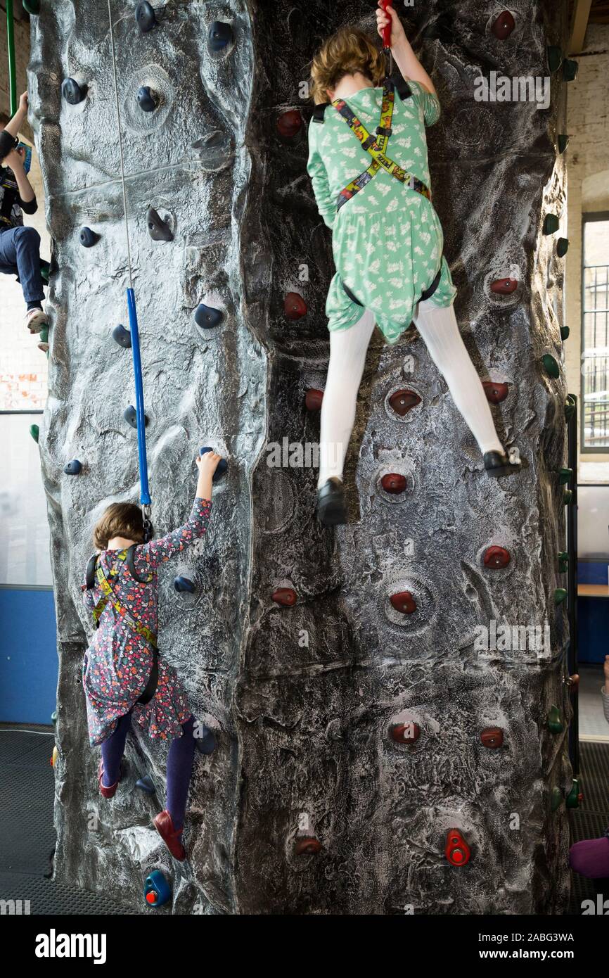 Junge Mädchen/zwei Schwestern/girl/Kind/Kind/Kinder Aktivität auf der Kletterwand an der Aktion Stationen, Portsmouth Historic Dockyard. Großbritannien (105) Stockfoto