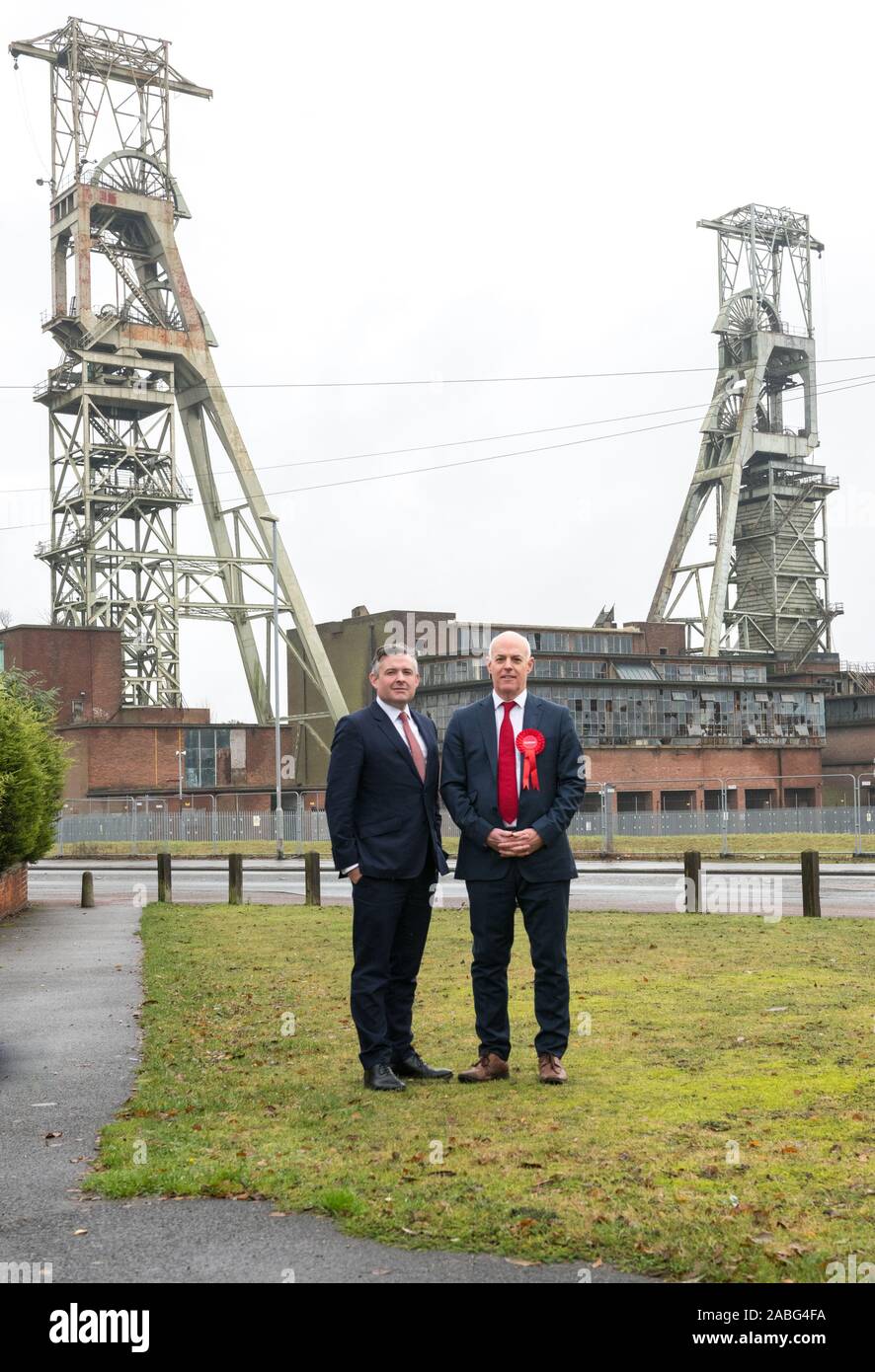 Clipstone, Nottinghamshire, England, UK. 27. November 2019. Jonathan Ashworth (Links) der Schatten Staatssekretär für Gesundheit und Jerry Haag (Rechts), Sherwood Labour Party Kandidaten, die in der Ex-bergbau Gemeinschaft der Clipstone folgende Ansage von Labour auf lunge Kliniken für pensionierte Bergarbeiter. Die einzige verbliebene Gebäude links steht der Zeche, die in 2003 abgeschlossen wurde, sind die Grad II Spindelstöcke, Europas höchstes Coal mining spindelstöcke an über 200 Fuß aufgeführt. Credit: Alan Beastall/Alamy leben Nachrichten Stockfoto