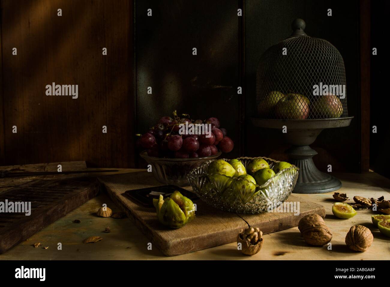 Herbst essen Hintergrund, Feigen und Nüsse, Äpfel und Trauben aroun, Dark Light Technik, kontrastreich Ton Stimmung und Rama hinzufügen, frontale Ansicht. Stockfoto