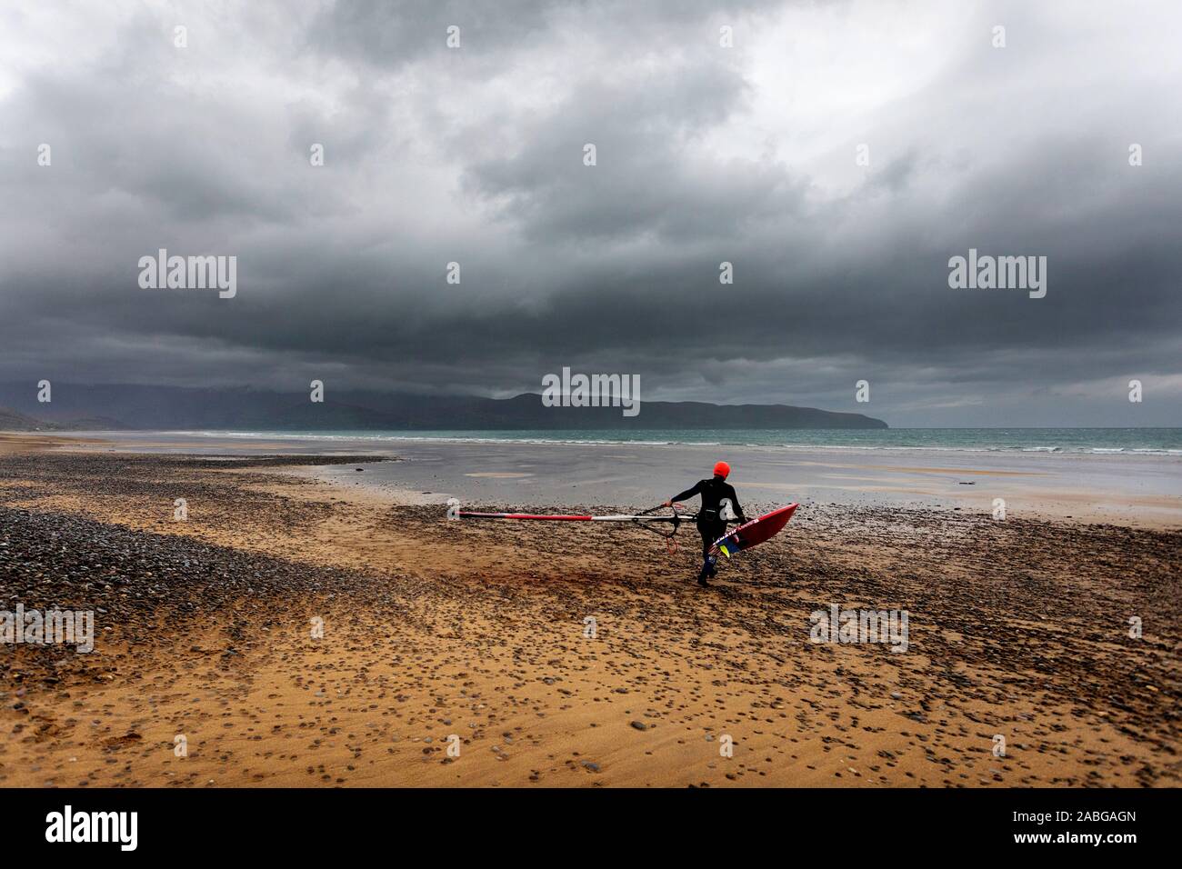 Windsurfer immer bereit zum Surfen am Strand bei stürmischem Wetter, County Kerry, Irland Stockfoto