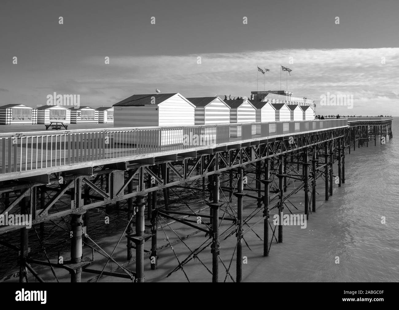 Es ist Oktober und die bunt gestreifte retail Strand Hütten auf Hastings Pier sind geschlossen. Stockfoto