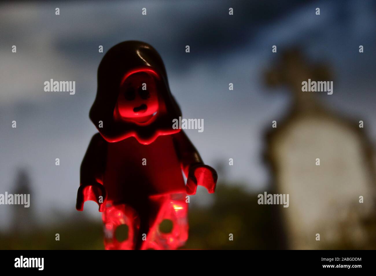 Ziemlich halloween Foto mit Lego minifigur von einem Phantom in einem Friedhof mit Flamme Stimmung und dunklen lustig Hintergrund Stockfoto