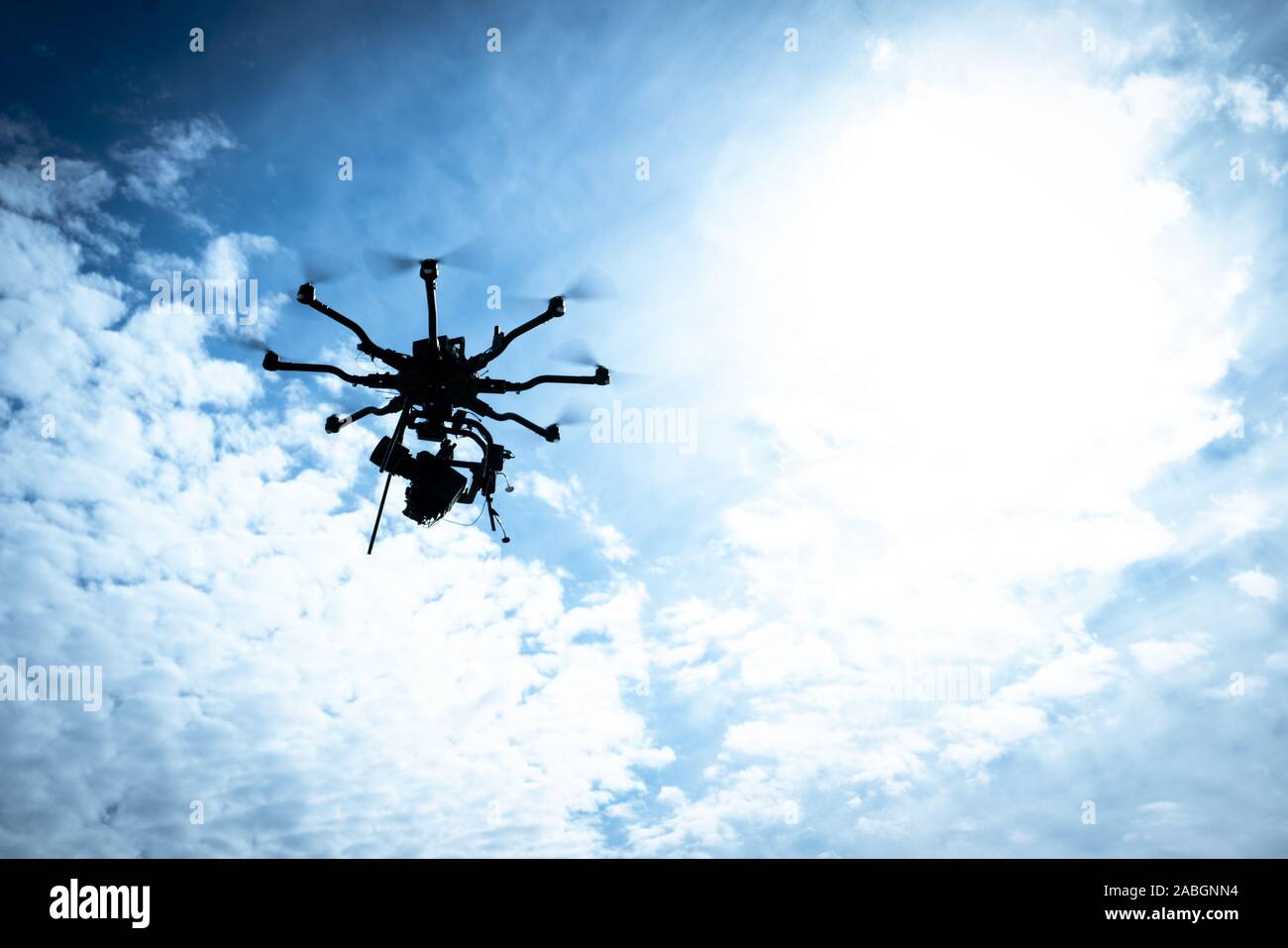 Große Drohne im Flug gegen den blauen Himmel und Wolken Stockfoto