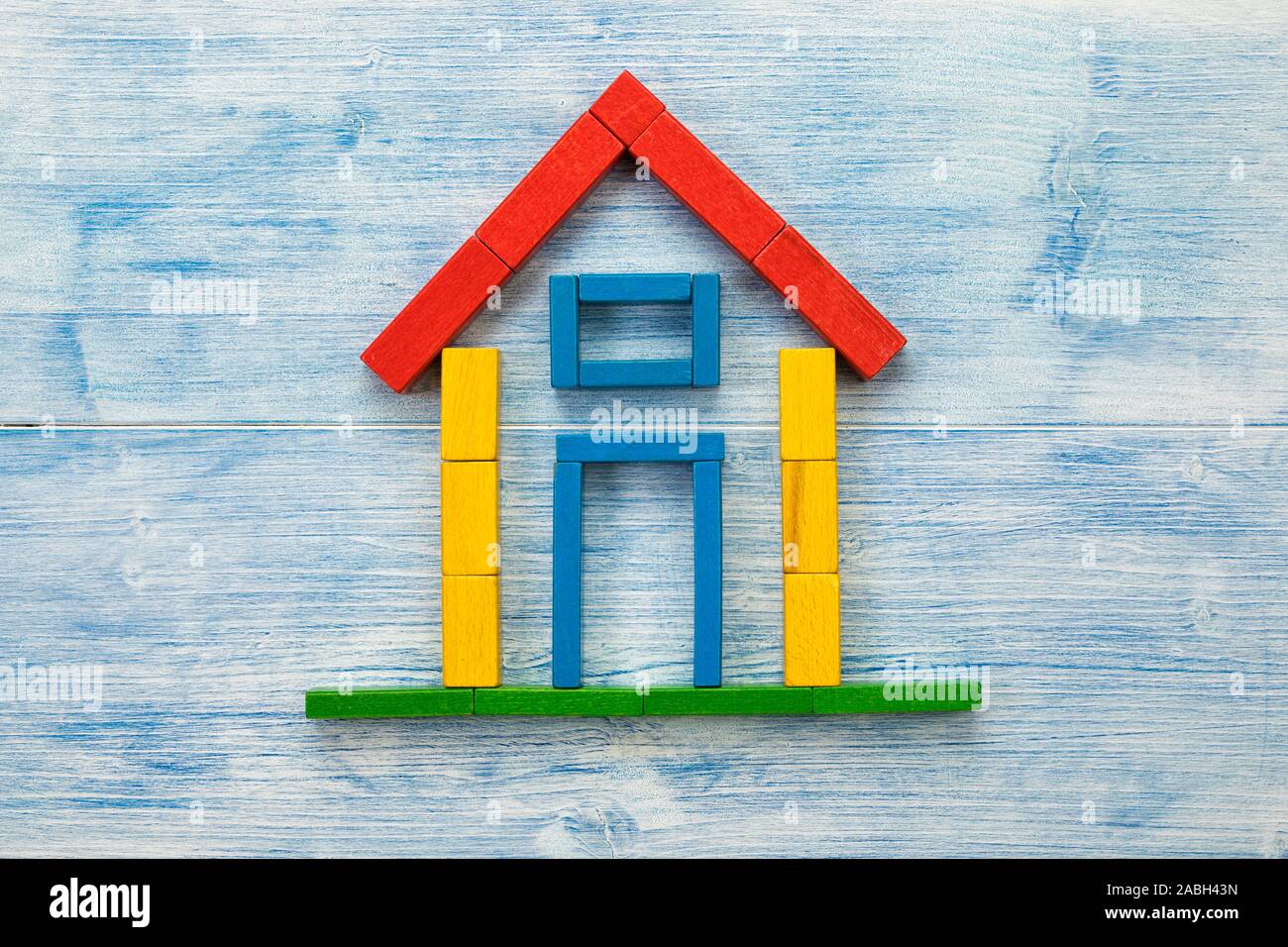 Haus aus Bausteinen auf Blau Holz Hintergrund flach Stockfoto