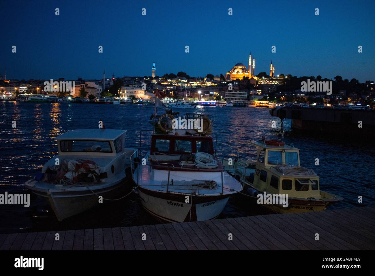 Istanbul: night skyline mit Booten in das Goldene Horn und die Süleymaniye-moschee, Ottoman Imperial Moschee von Suleiman dem Prächtigen im Auftrag Stockfoto