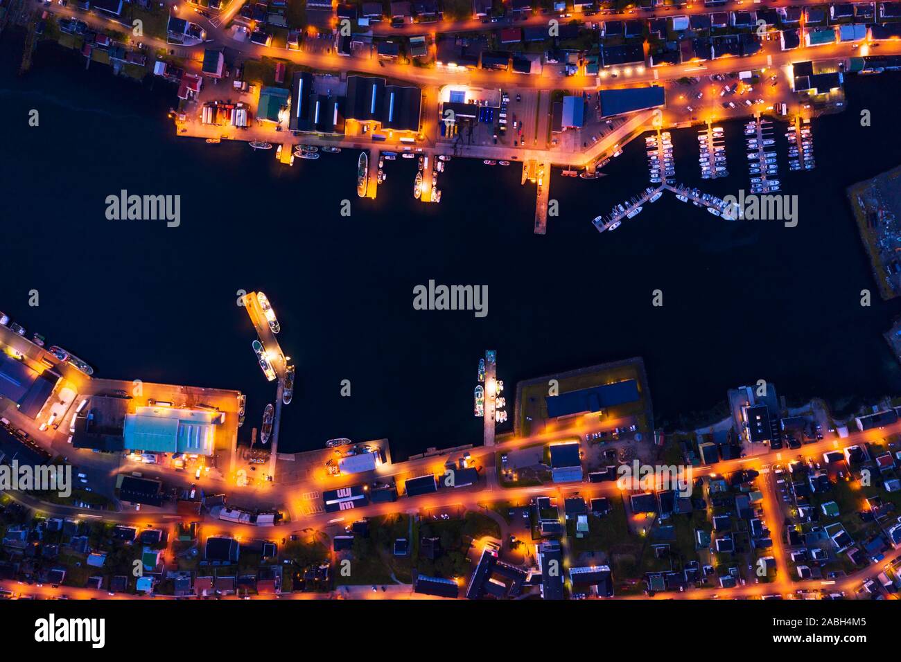 Fantastische Luftaufnahmen abend Stadtbild von klaksvik Stadt mit glühenden Pier, Schiffe und Boote, bordoy Island, Färöer, Dänemark. Landschaftsfotografie Stockfoto