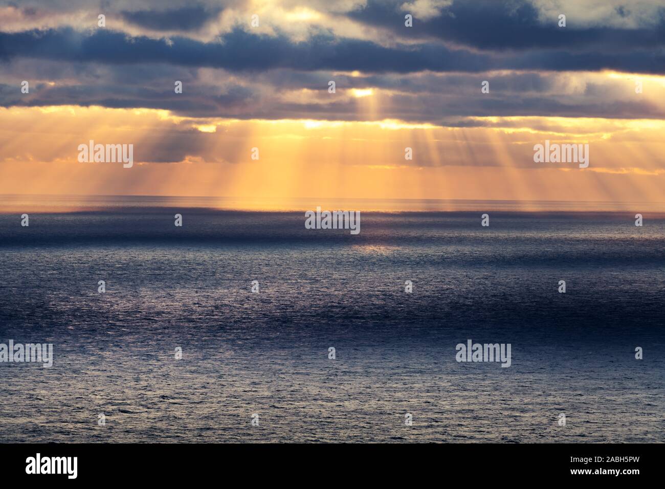 Sonnenuntergang im Meer mit glühenden Sonnenstrahlen und bewölktem Himmel. Meer Sonnenaufgang Hintergrund. Landschaftsfotografie Stockfoto