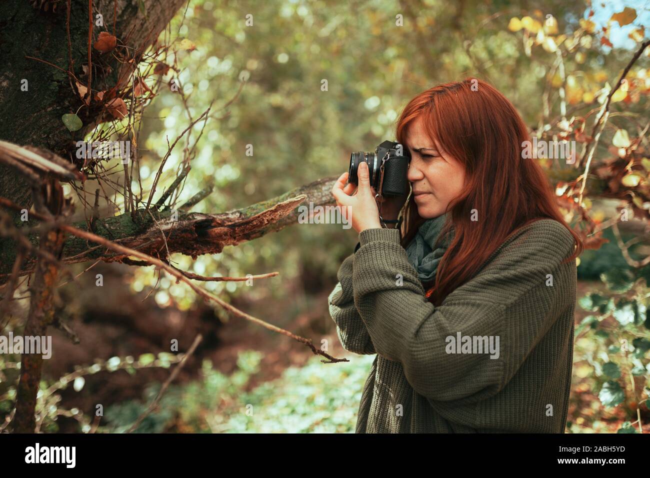 Junge Frau die Bilder im Wald mit einem alten analogen Kamera Stockfoto