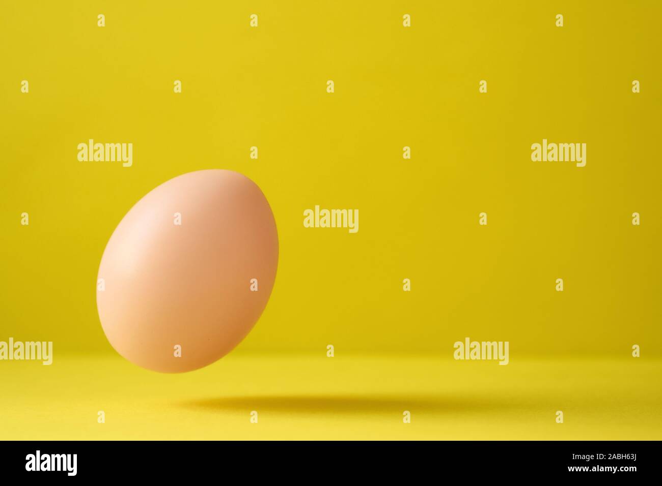 Hühnerei fallen auf Grund gegen gelben Hintergrund Stockfoto