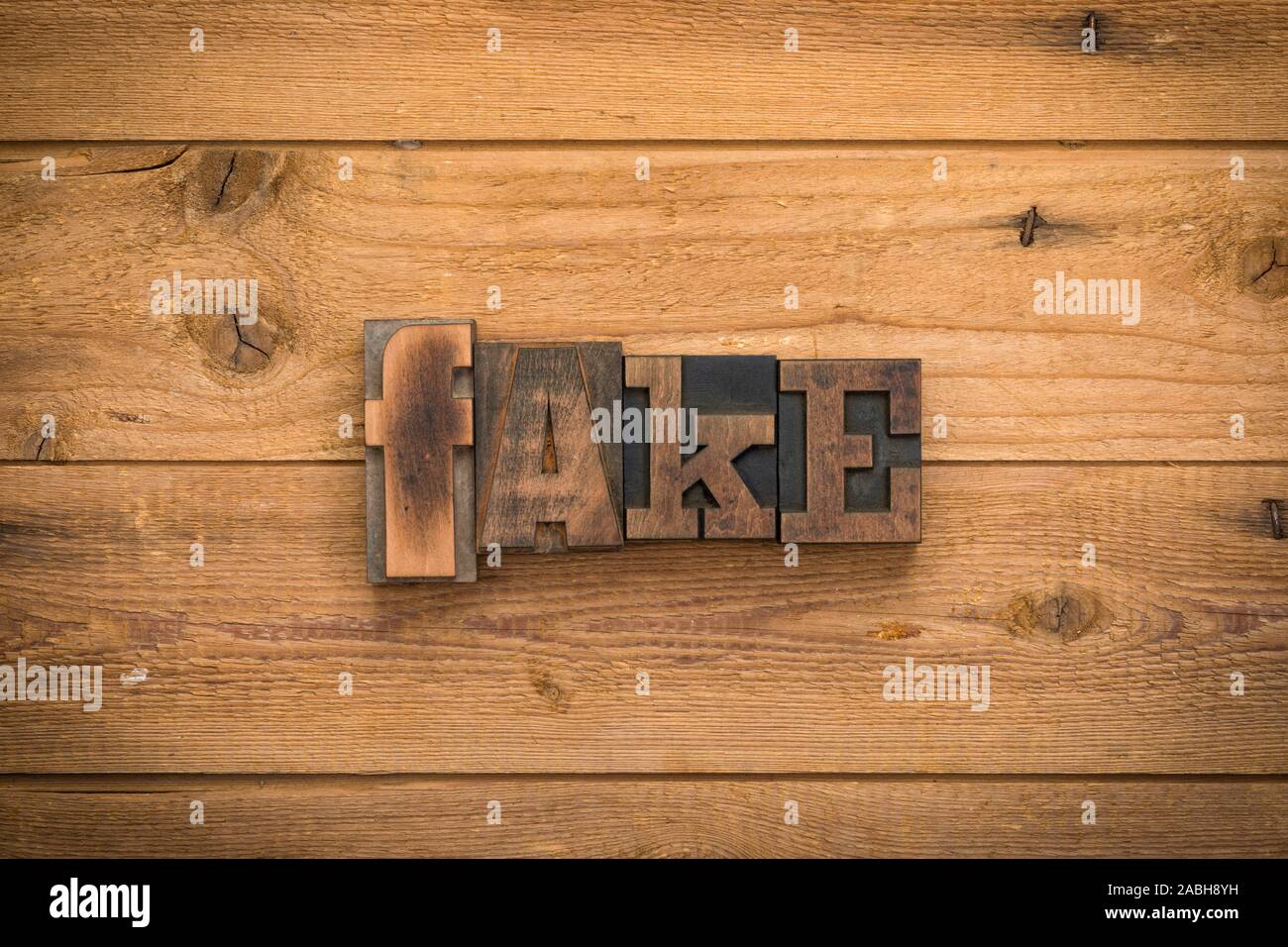 Fake, einzelnes Wort mit Vintage Buchdruck Blöcke auf rustikalem Holz Hintergrund geschrieben. Stockfoto