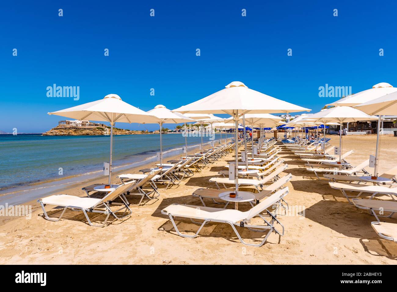 Naxos, Griechenland - 22. Mai 2017: Sonnenliegen mit Sonnenschirmen am Strand von Agios Georgios, sehr beliebten Ferienort auf der Insel Naxos Stockfoto