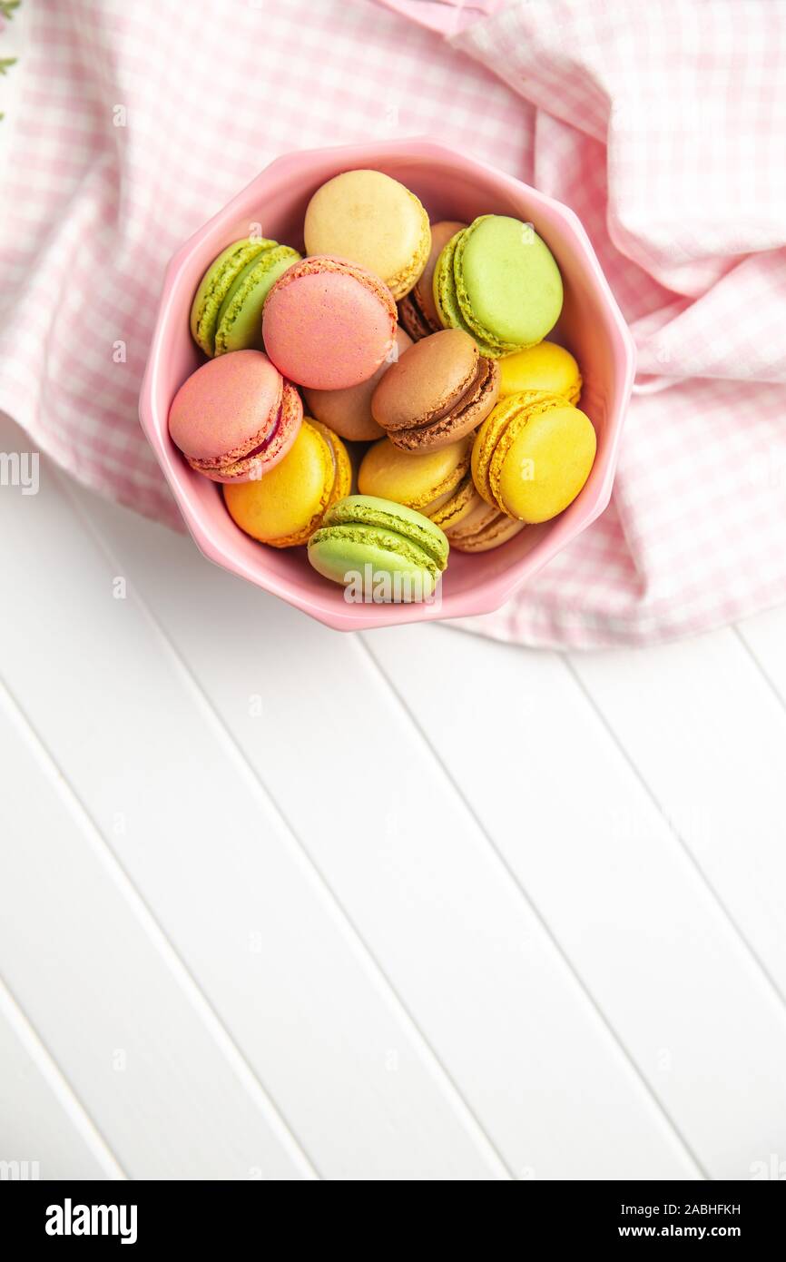 Süße bunte Macarons in Schüssel auf weißer Tisch. Ansicht von oben. Stockfoto